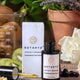 Botanyx skincare serum with packaging on a wooden surface with plants in the background